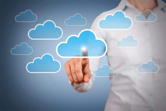 Person interacting with a cloud computing interface, touching a digital cloud icon on a blue background to represent cloud services and technology.