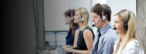 Customer support team wearing headsets working at desks, representing collaboration and communication enabled by Microsoft Teams.