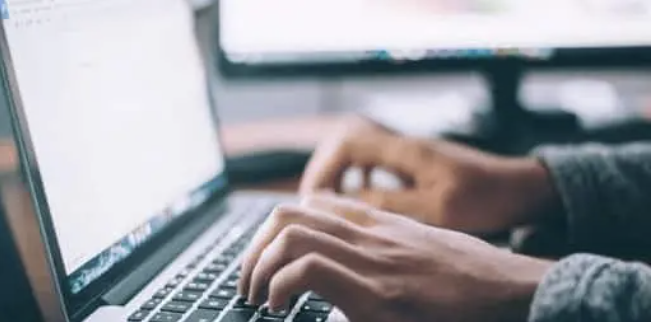 Hands typing on a laptop keyboard, representing security operations work, threat monitoring, and SOC outsourcing support.